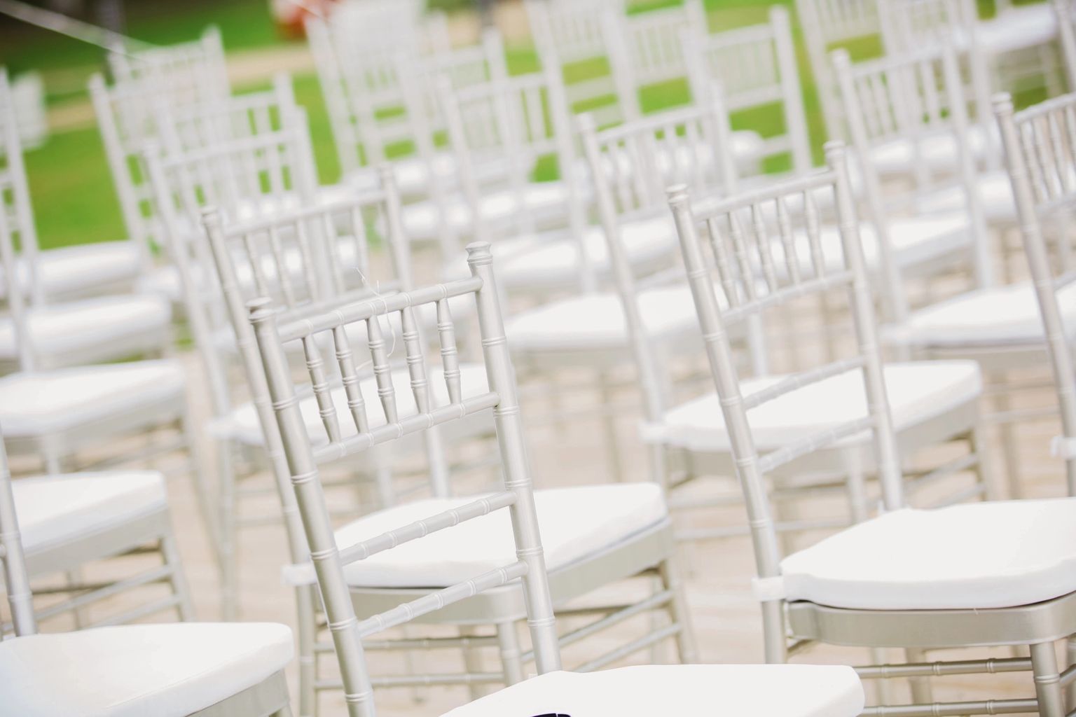 A bunch of white chairs are lined up in rows