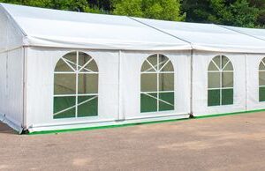 A white tent with green windows on the side of it.