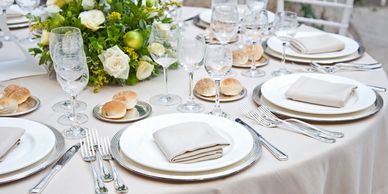 A table set with plates, silverware and napkins.