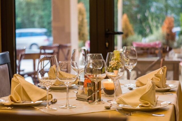 A table set with wine glasses and napkins.